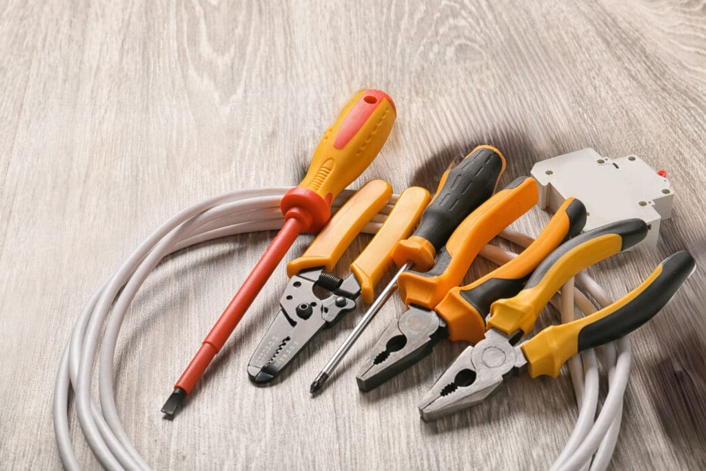 Different electrician's supplies on wooden floor